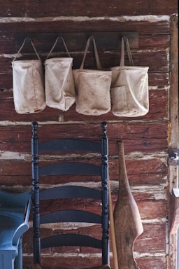 A cozy shoulder bag hanging on a rustic hook against a warm, inviting background.