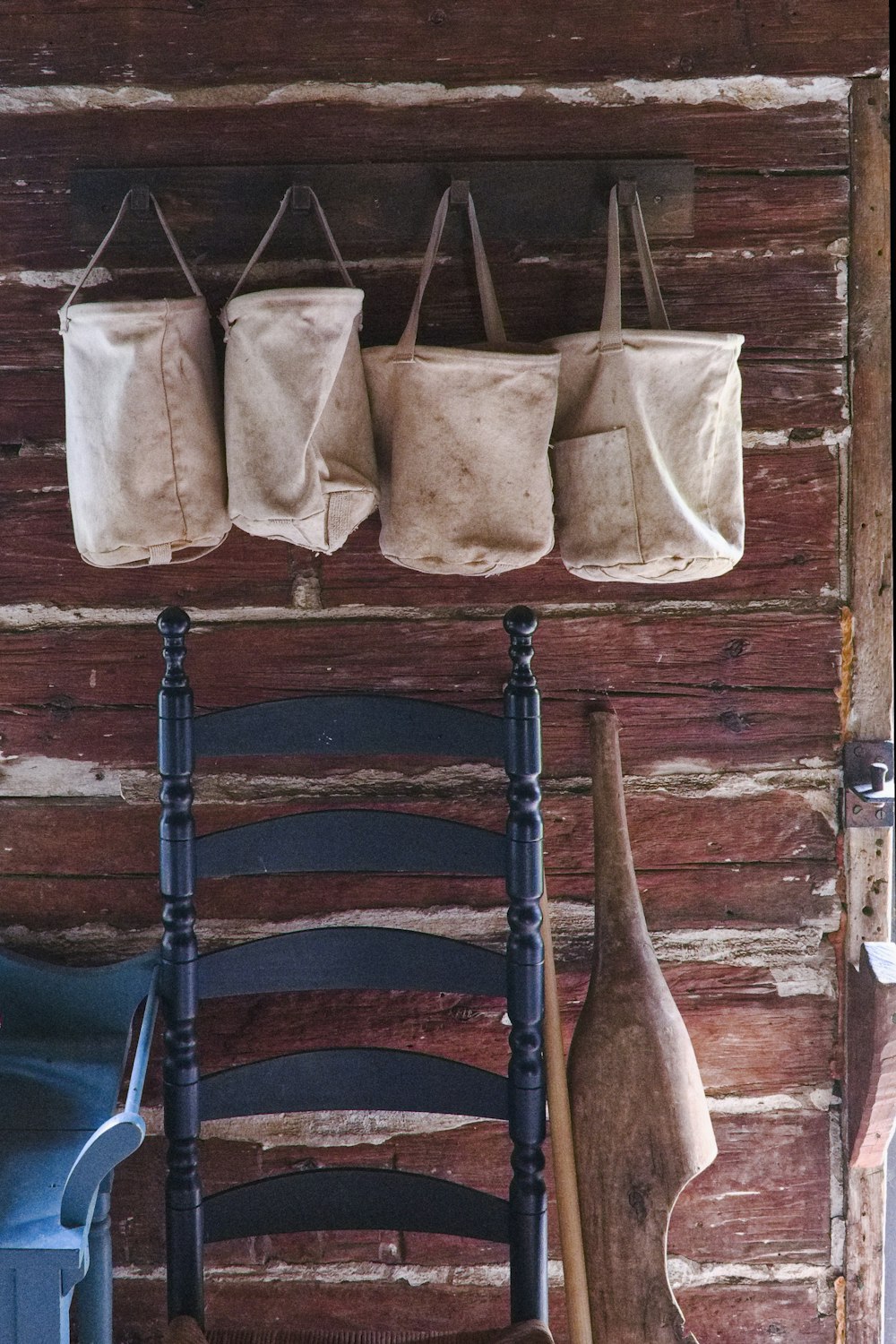 a wooden wall with three bags hanging on it