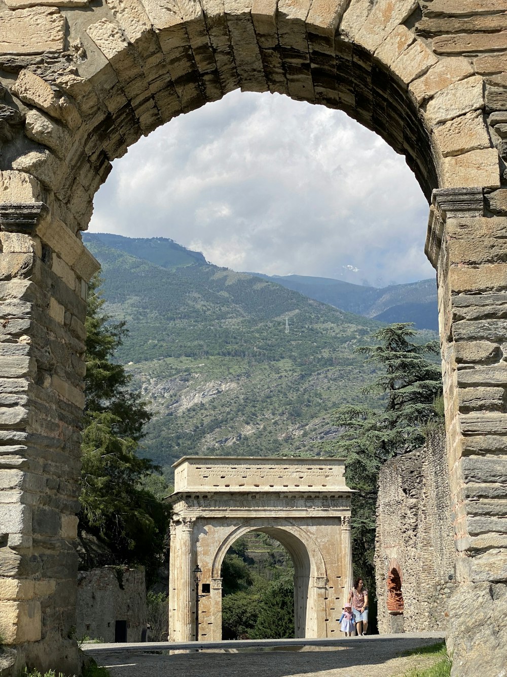 a stone arch with a mountain in the background