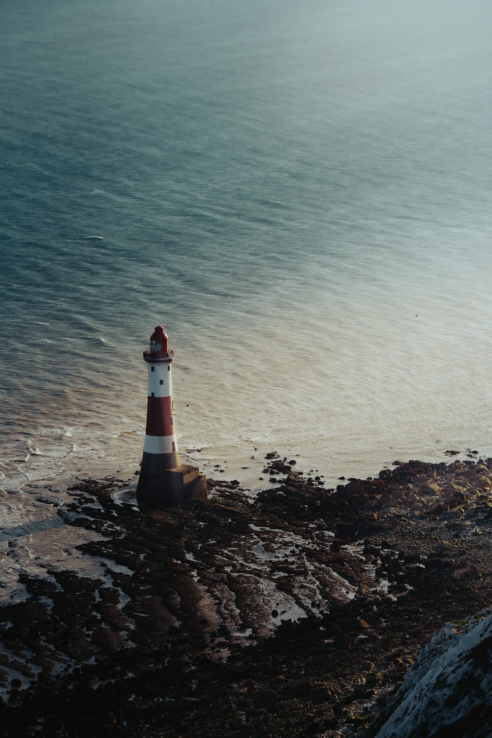 a light house sitting on top of a rocky beach