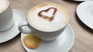 A steaming cup of traditional Brazilian coffee with a small cookie on the side