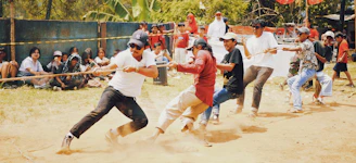 Three distinct tribal groups competing fiercely in a tug-of-war challenge in the forest.