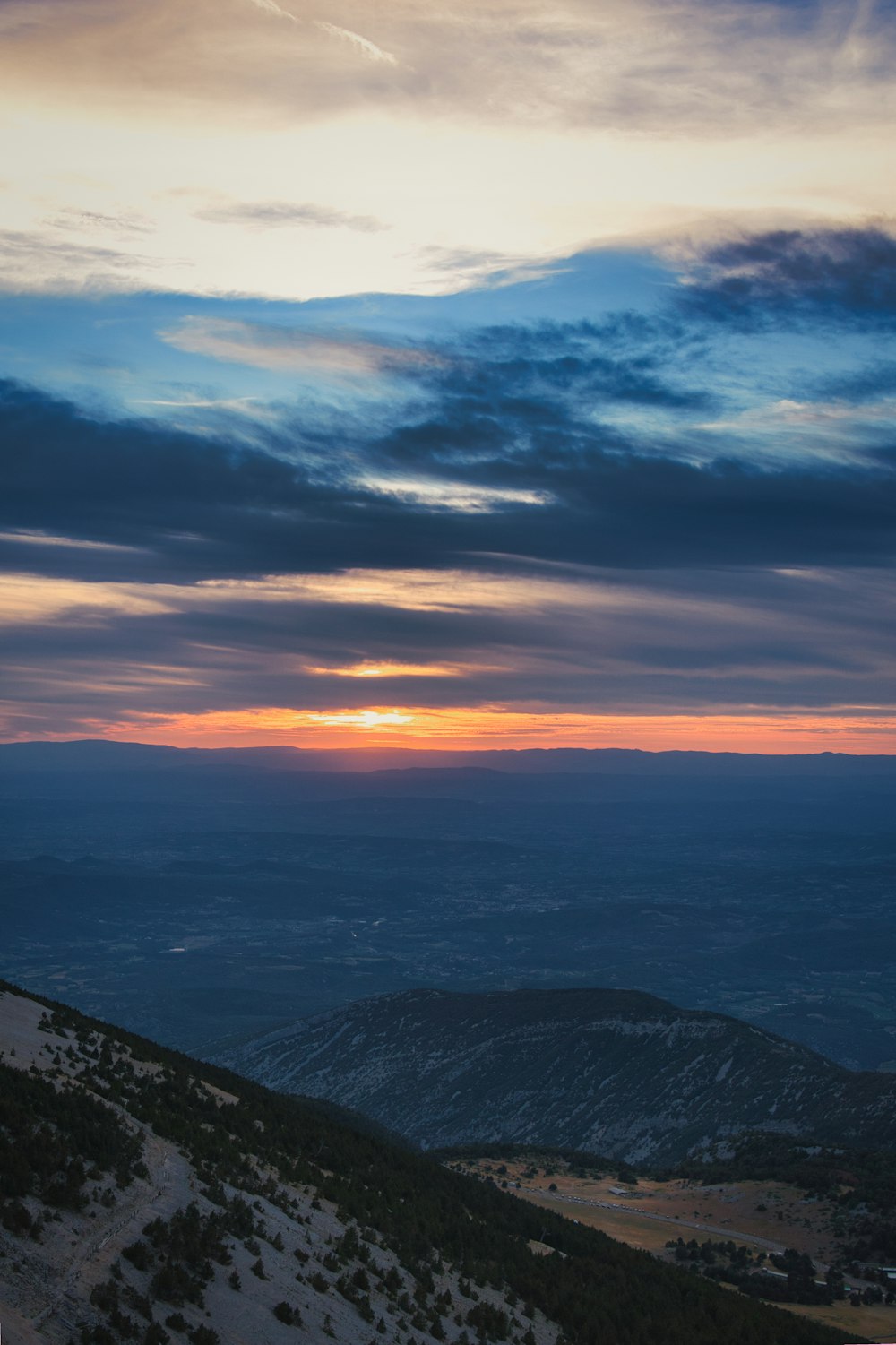 the sun is setting over a mountain range