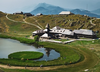 a house on a hill with a lake in front of it