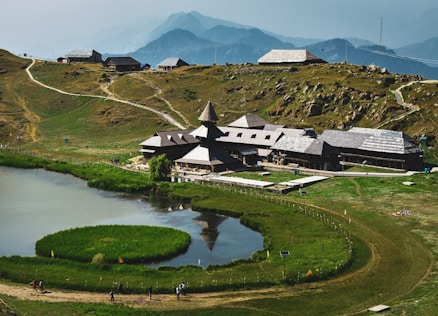 a house on a hill with a lake in front of it
