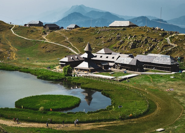 a house on a hill with a lake in front of it