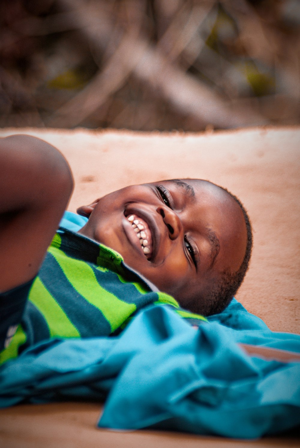 a little boy laying on the ground laughing