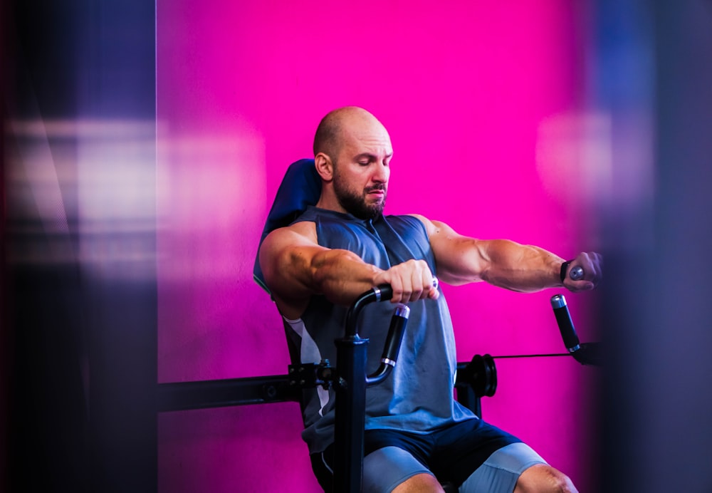 a man sitting on top of a bench holding a bar