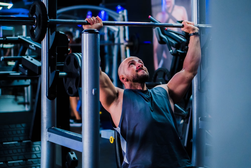 a man doing a pull up on a bar in a gym