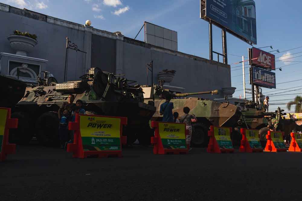 a group of people standing next to military vehicles