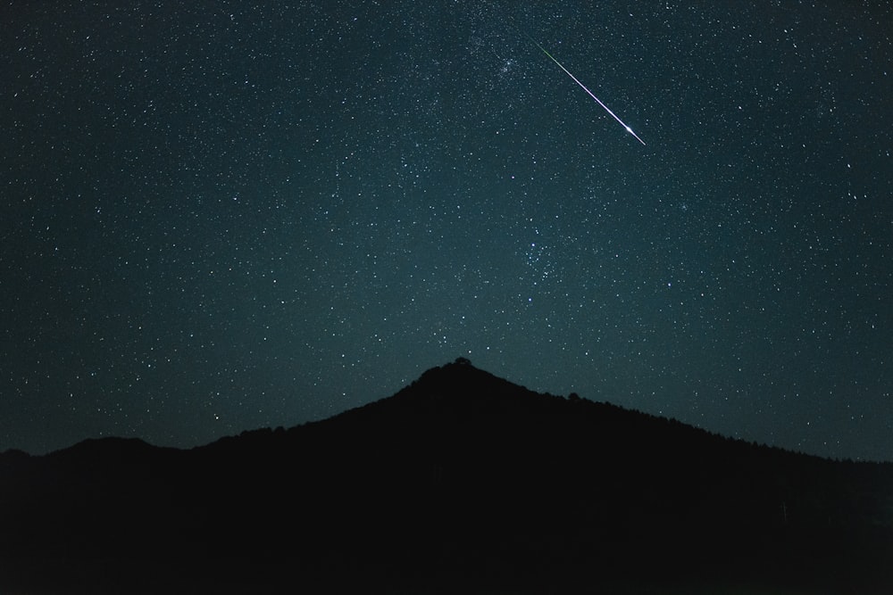 Un cielo notturno con stelle e una stella cadente