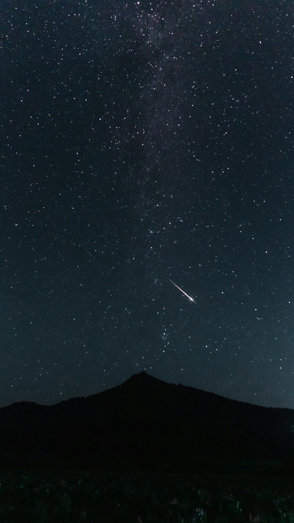 O céu noturno com estrelas e uma estrela cadente