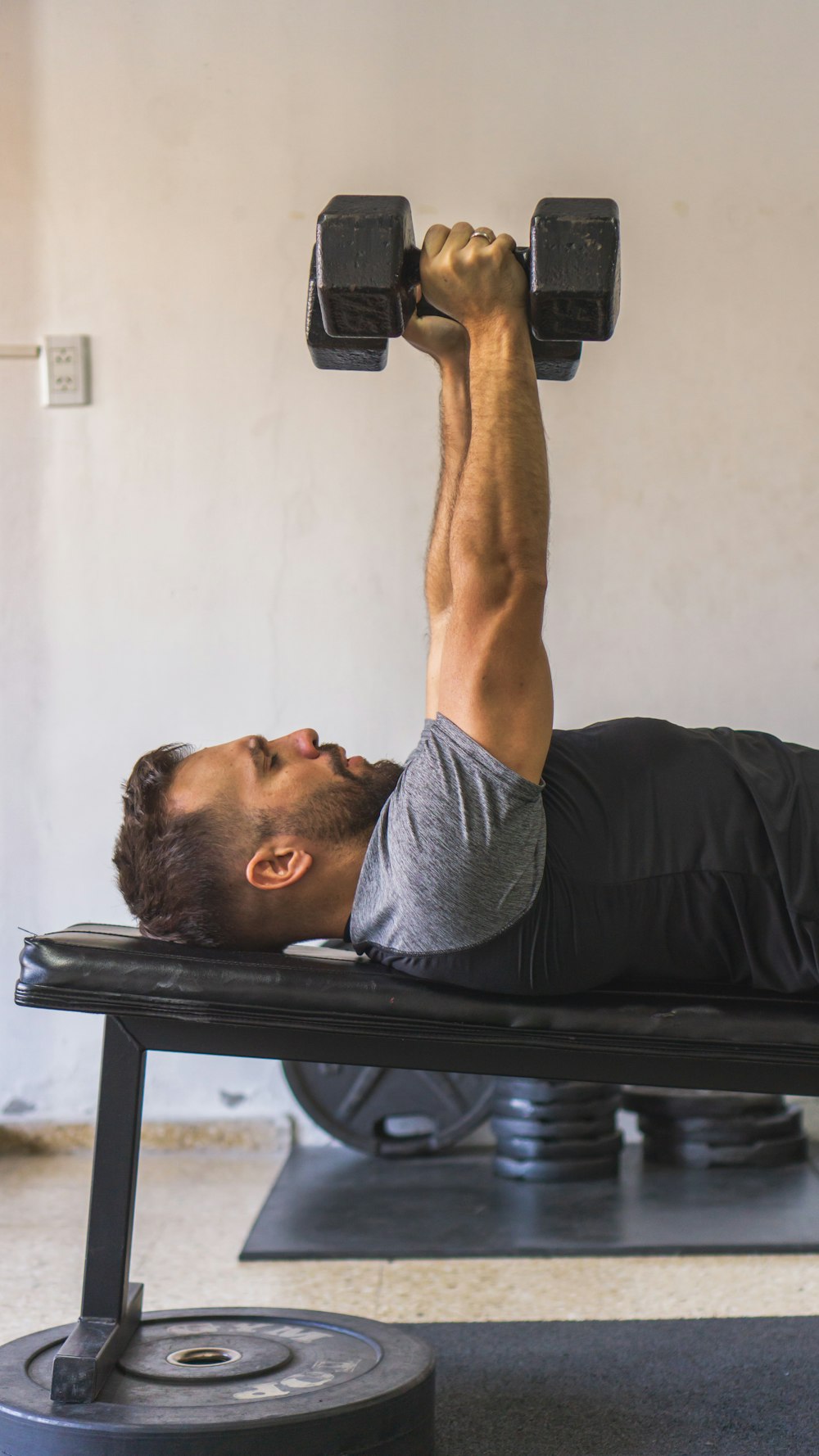 a man doing a bench press with a dumbbell