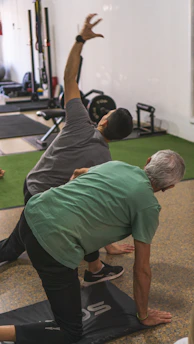 a couple of men standing on top of a yoga mat