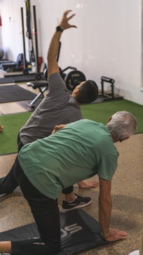a couple of men standing on top of a yoga mat