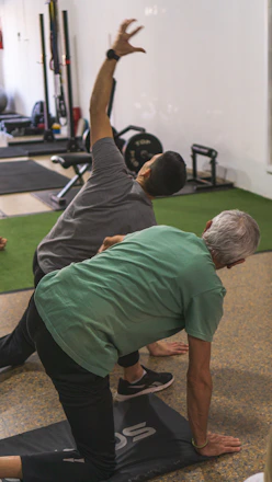 a couple of men standing on top of a yoga mat