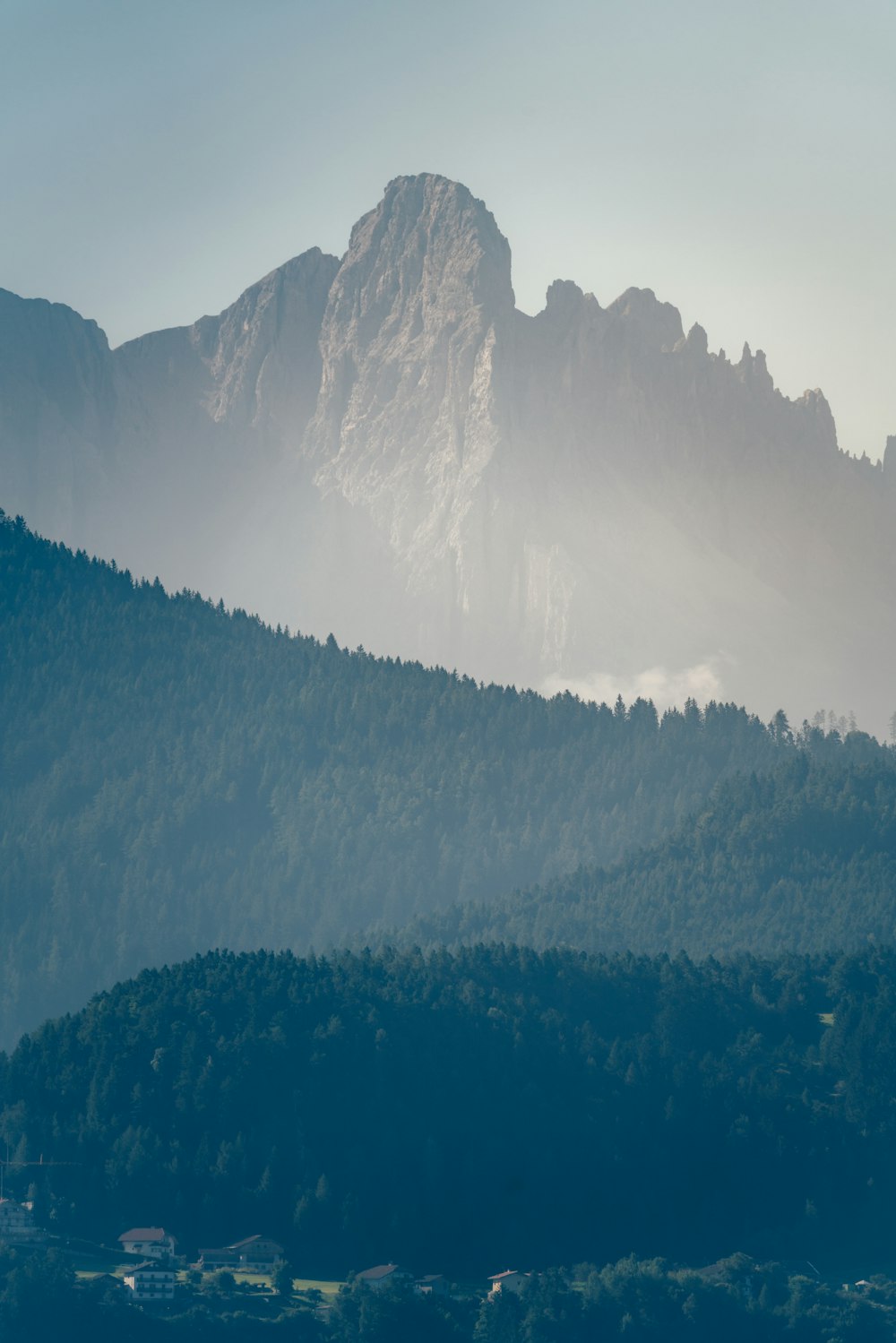 a view of a mountain range with trees in the foreground