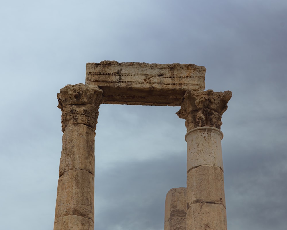 a tall stone structure with two smaller pillars