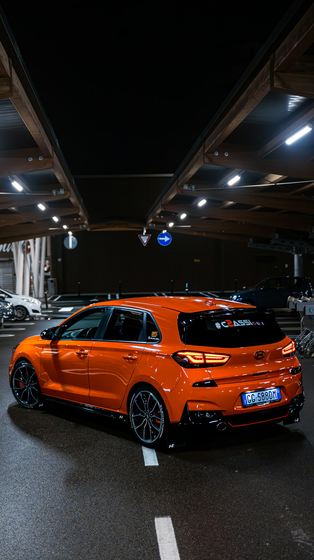an orange car parked in a parking garage