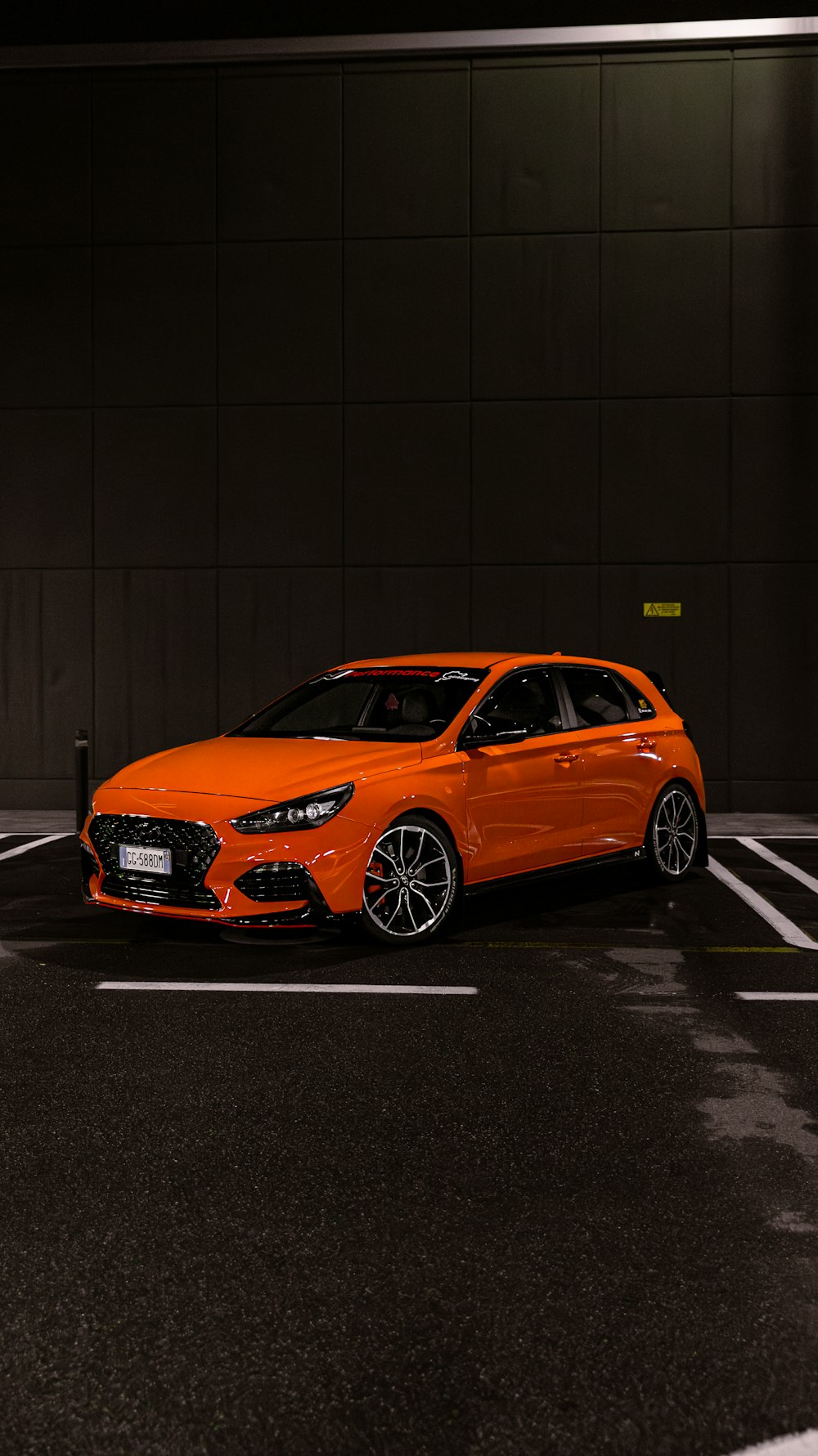 an orange car parked in a parking lot