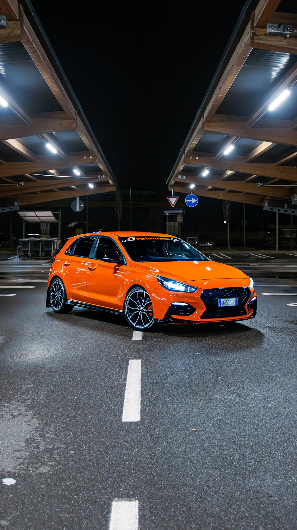 an orange car parked in a parking garage