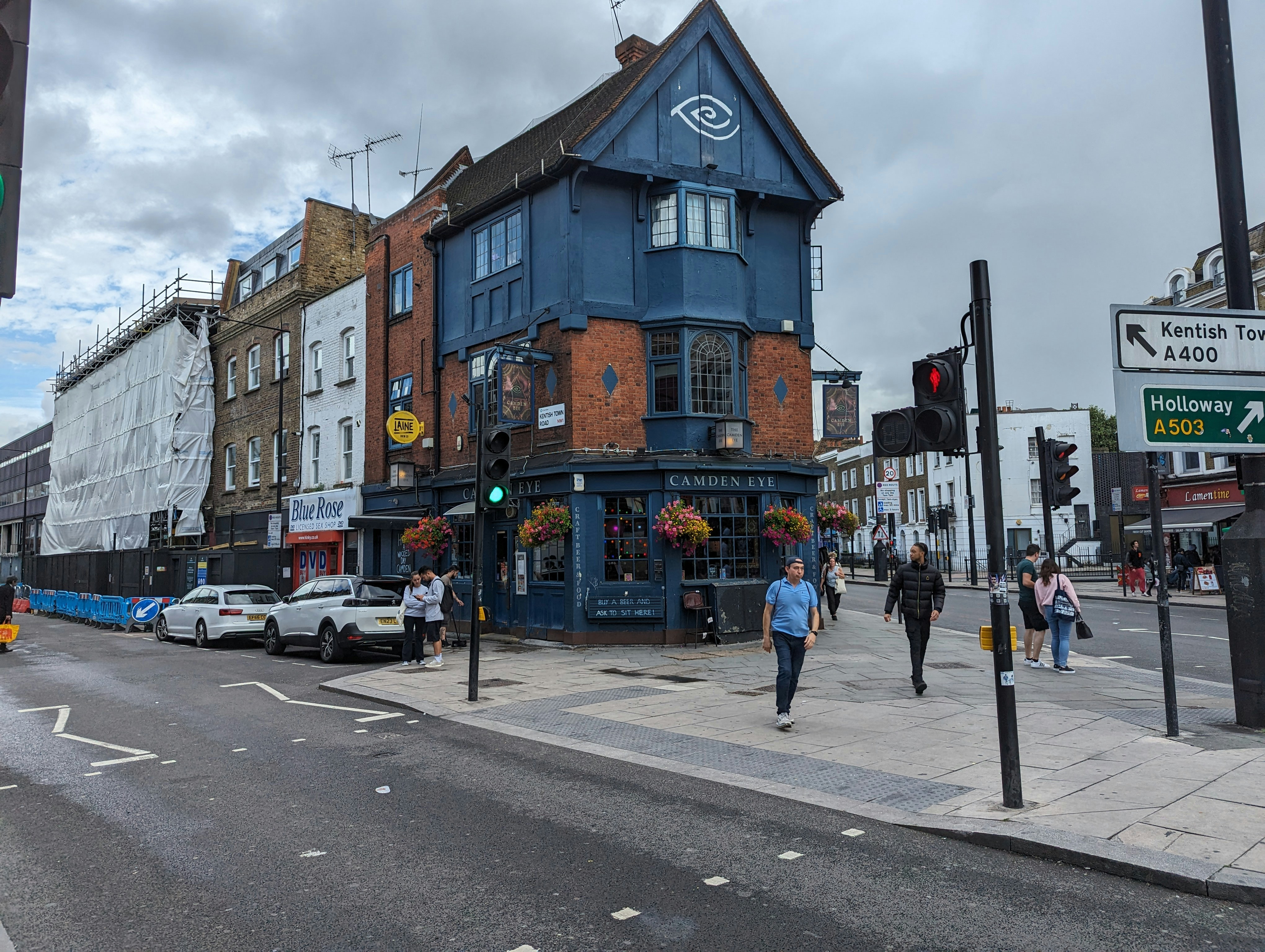 a group of people walking down a street next to tall buildings