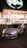 A sleek white car with prominent front lights is parked in front of a brightly lit modern building at nighttime. The building has large glass windows and a sign reading 'Pogliano Milanese.' The glowing brand sign, 'globo,' is prominently displayed above the entrance.