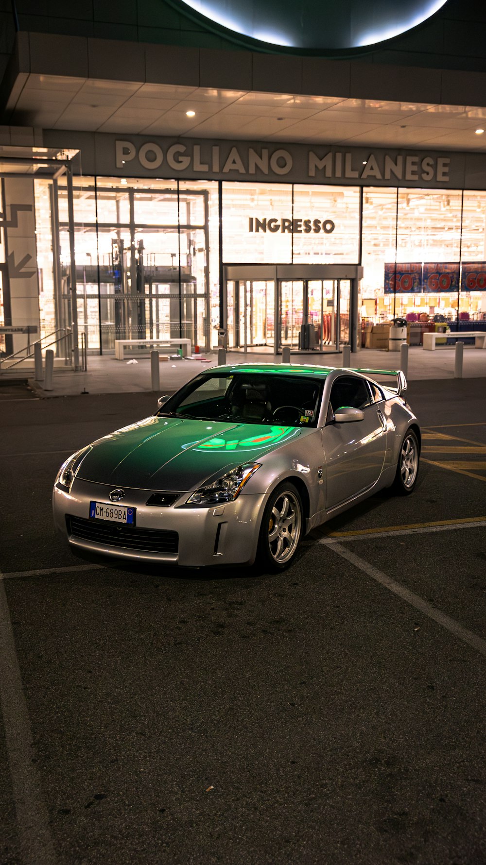 a silver sports car parked in front of a building