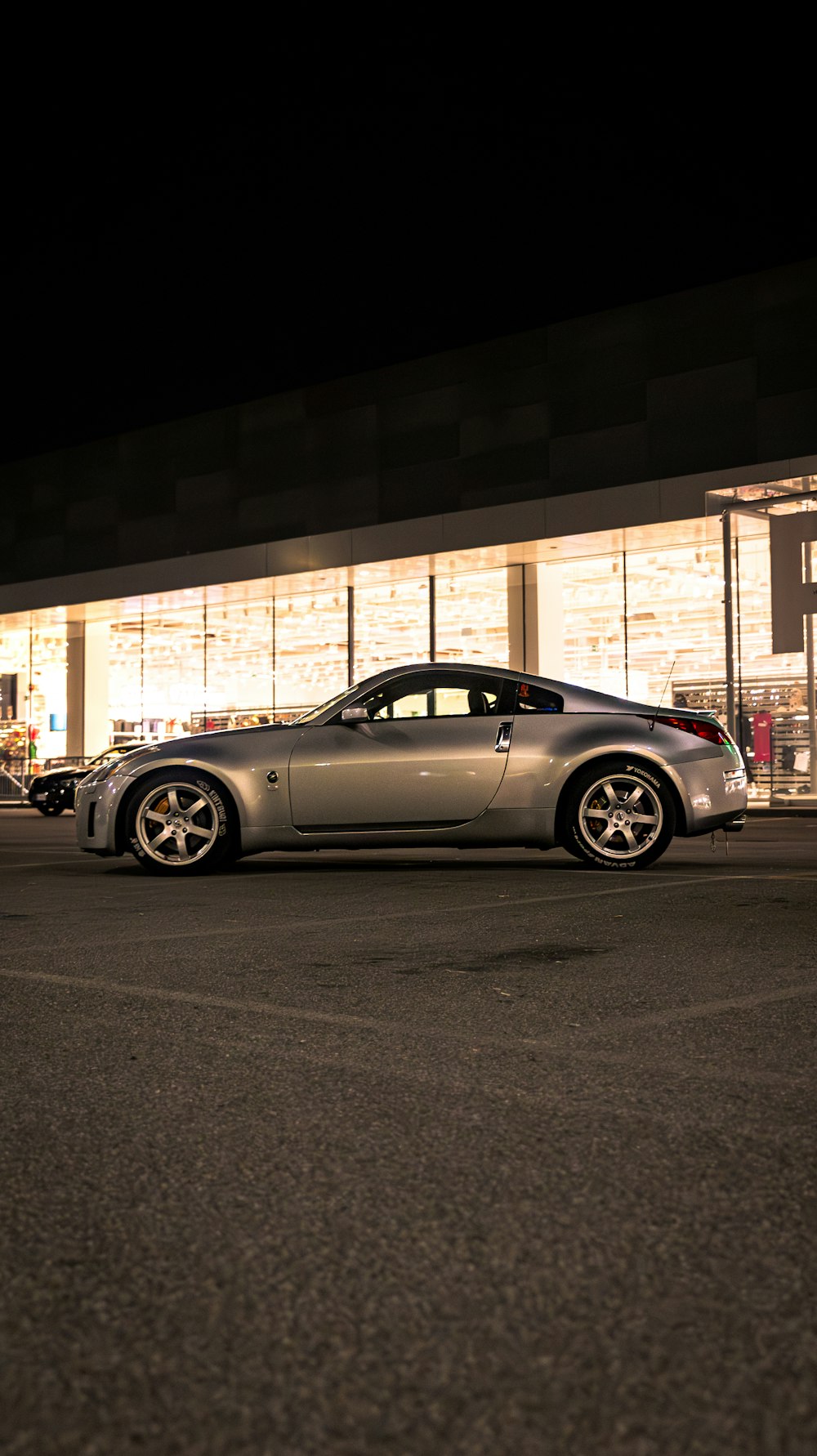 a silver sports car parked in front of a building