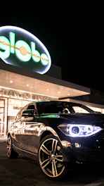 A sleek car driving through Bogotá streets with a visible GNV sticker on the windshield.