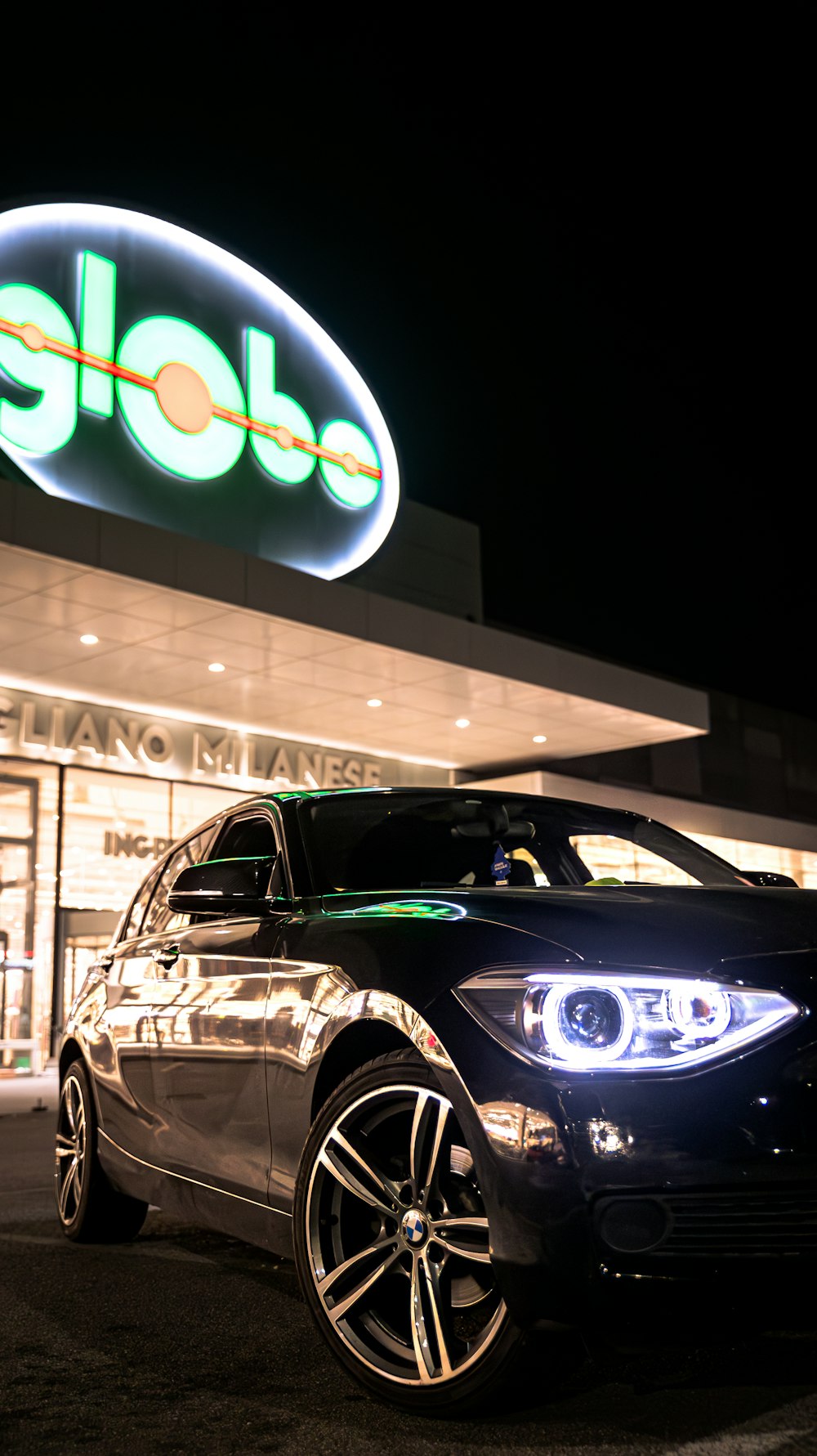 a black car parked in front of a store