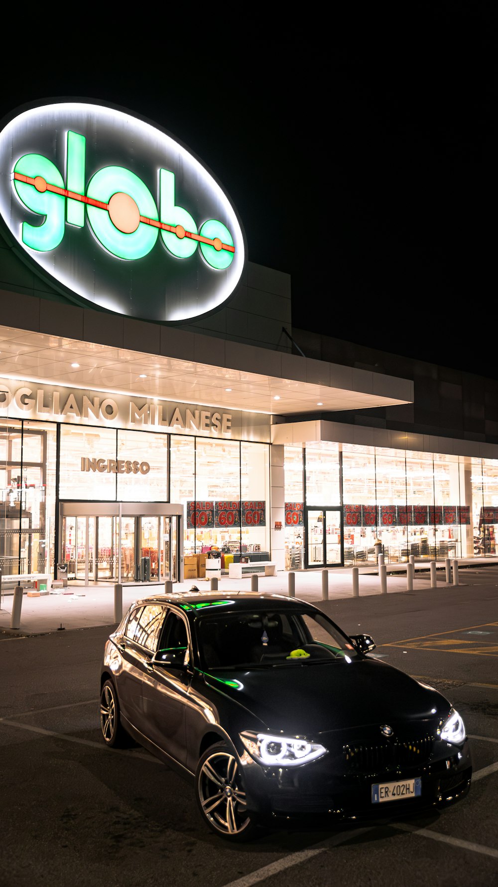 a car parked in front of a store at night