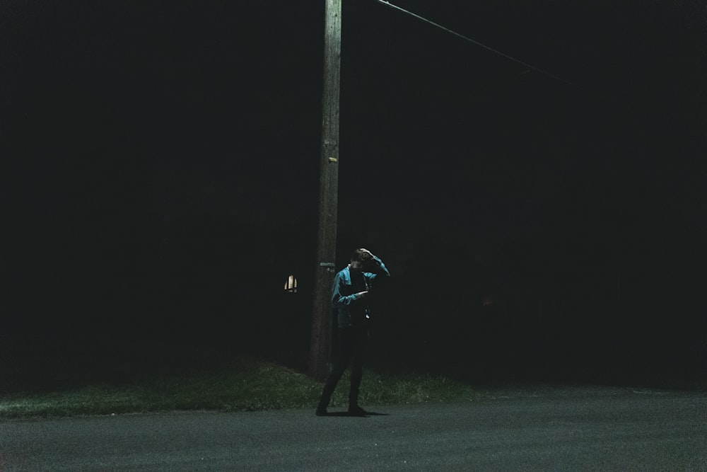 a person standing under a street light at night