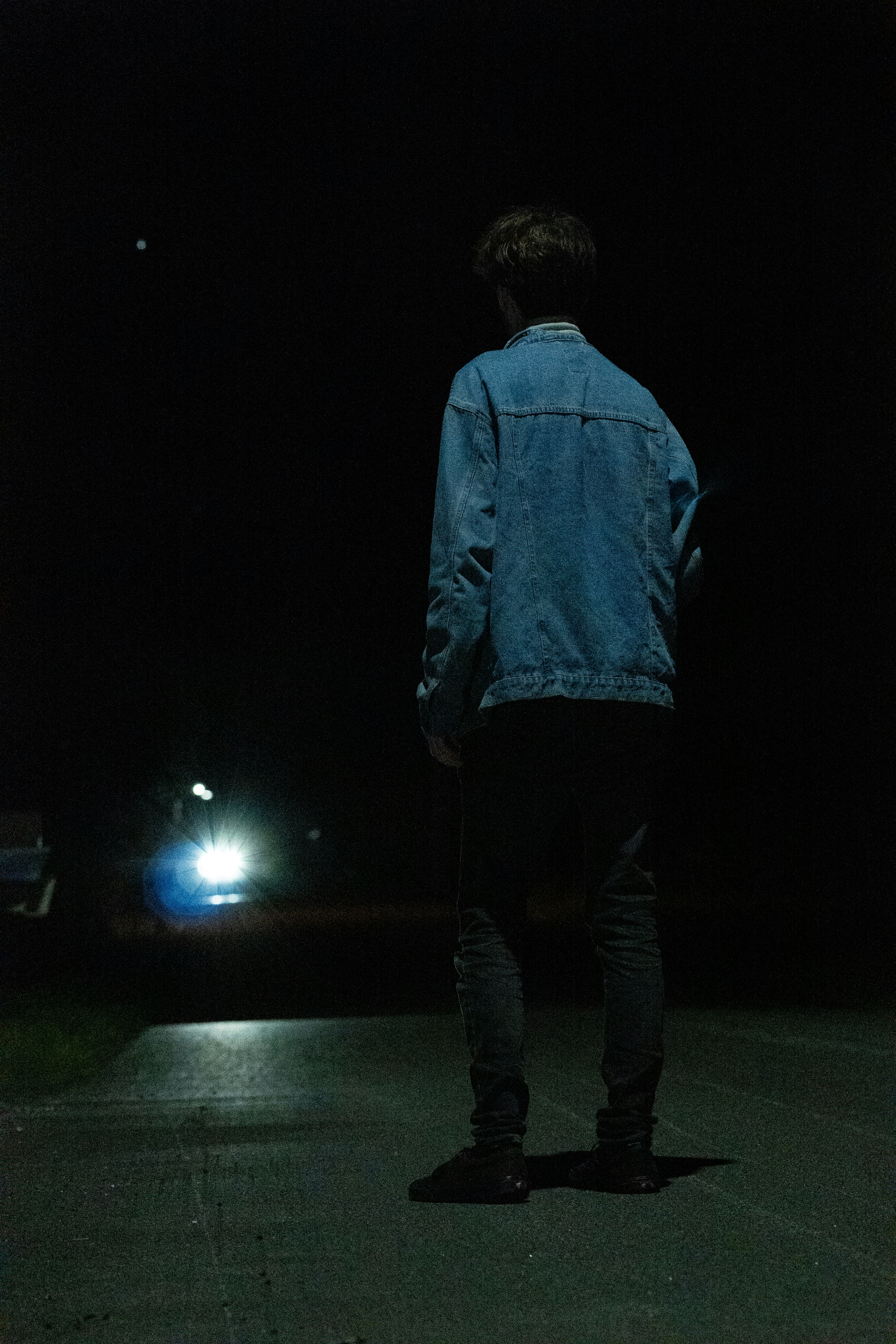 ein mann, der nachts eine straße entlanggeht