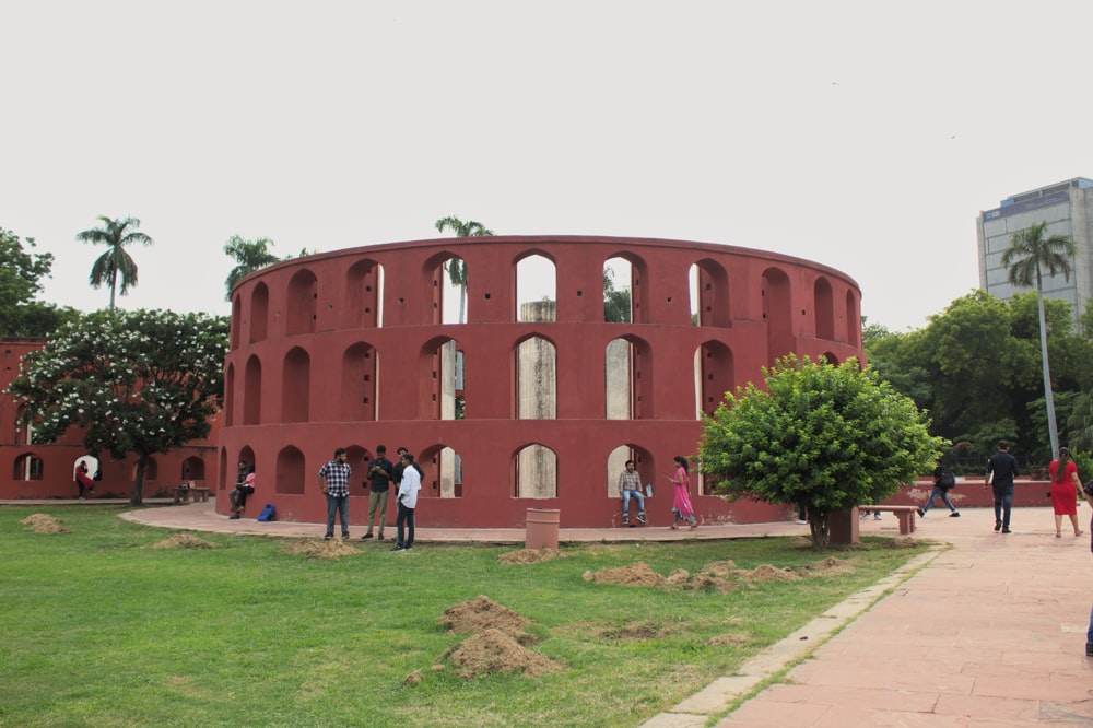 a group of people standing in front of a red building