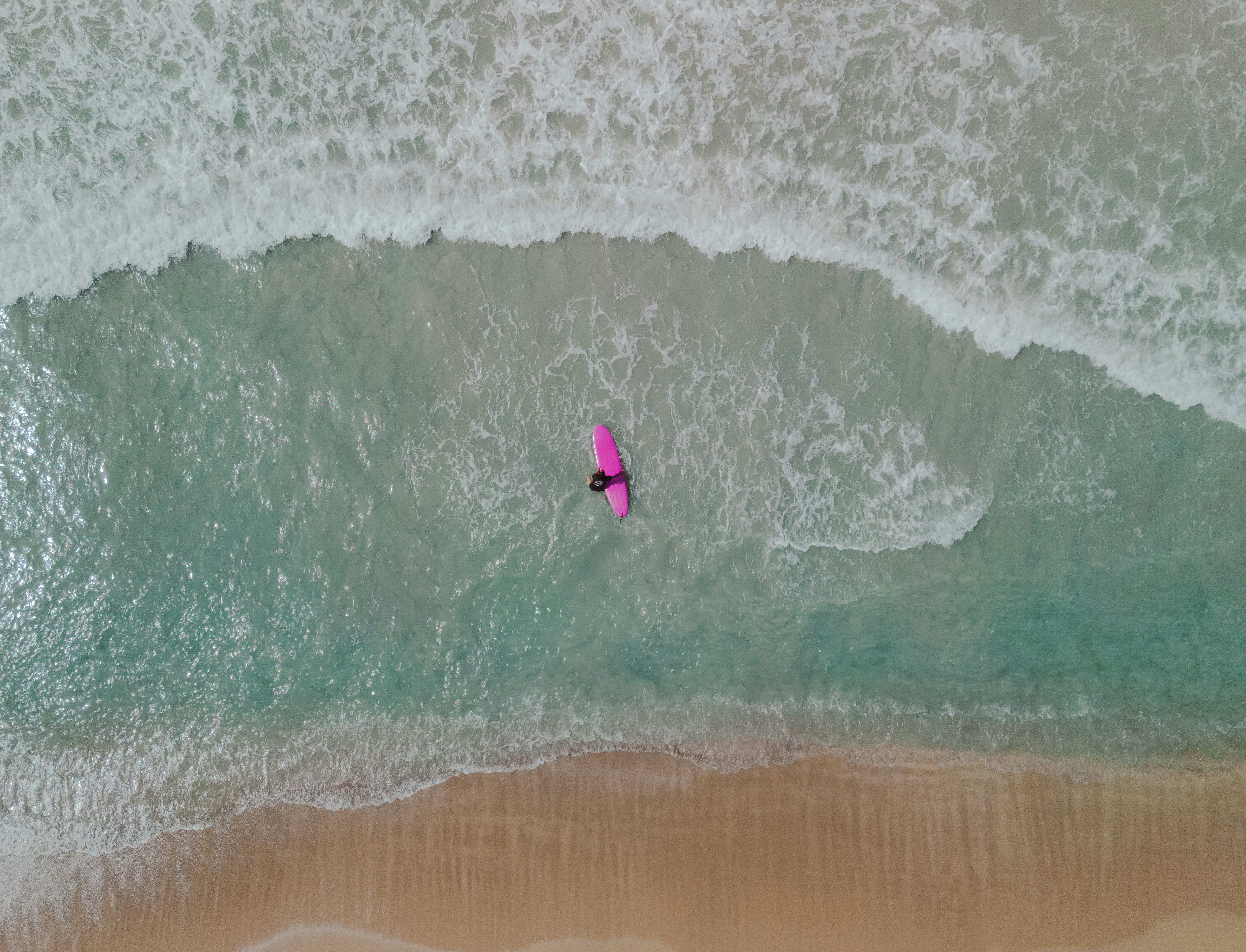 Foto Una persona montando una tabla de surf encima de una ola Imagen