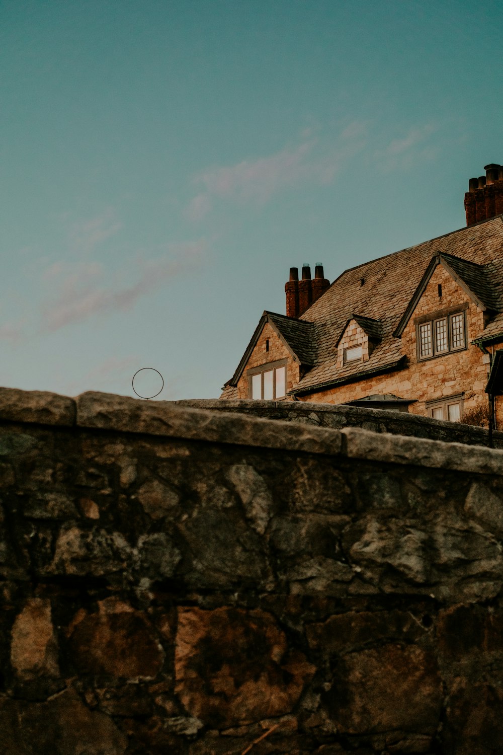 a stone wall with a building in the background