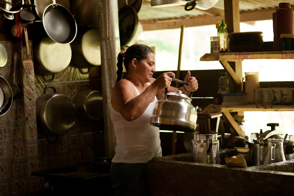 a woman standing in a kitchen preparing food