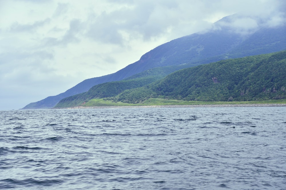 a large body of water with mountains in the background