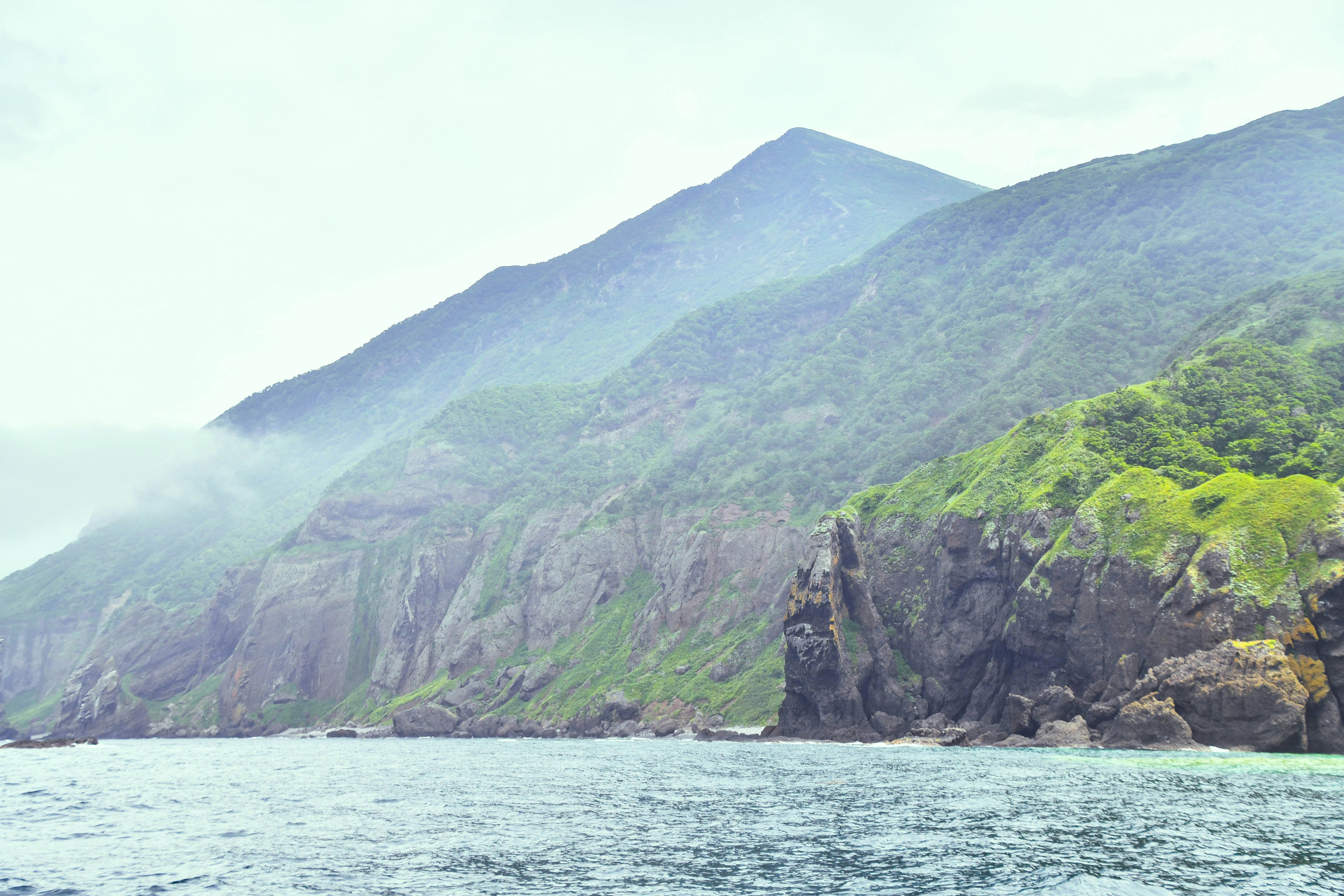 a large body of water with a mountain in the background, Coast near volcano Bohdan Khmelnytsky