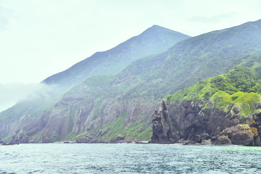 a large body of water with a mountain in the background