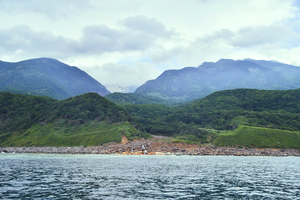 a large body of water with mountains in the background