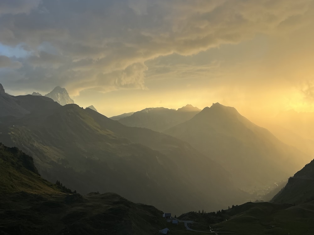 the sun is setting over a mountain range