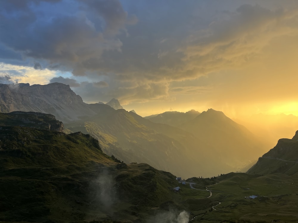 the sun is setting over a mountain range