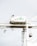 A large industrial crane is situated in a port setting. The crane has a white structure with a green logo that reads 'SSA Terminals.' The crane features various cables and machinery, including a suspended container or object being lifted. The background is a pale sky, creating a stark contrast with the crane's structure.