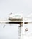 A large industrial crane is situated in a port setting. The crane has a white structure with a green logo that reads 'SSA Terminals.' The crane features various cables and machinery, including a suspended container or object being lifted. The background is a pale sky, creating a stark contrast with the crane's structure.