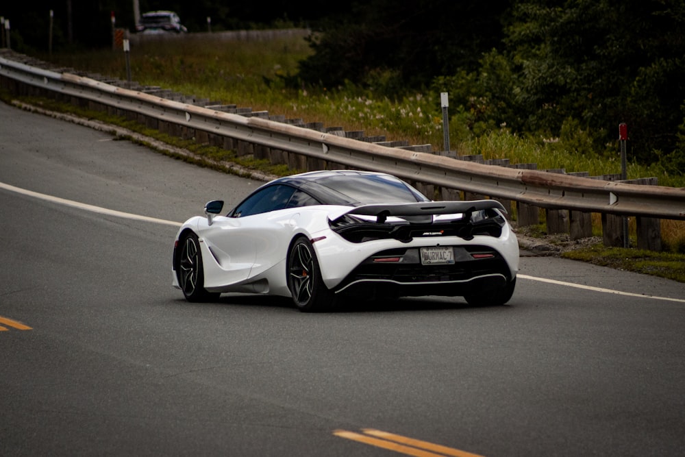 um carro esportivo branco dirigindo pela estrada