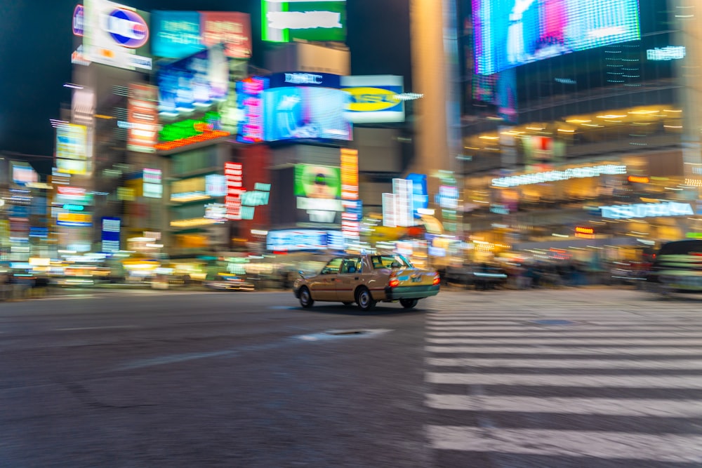 a taxi cab driving down a city street at night