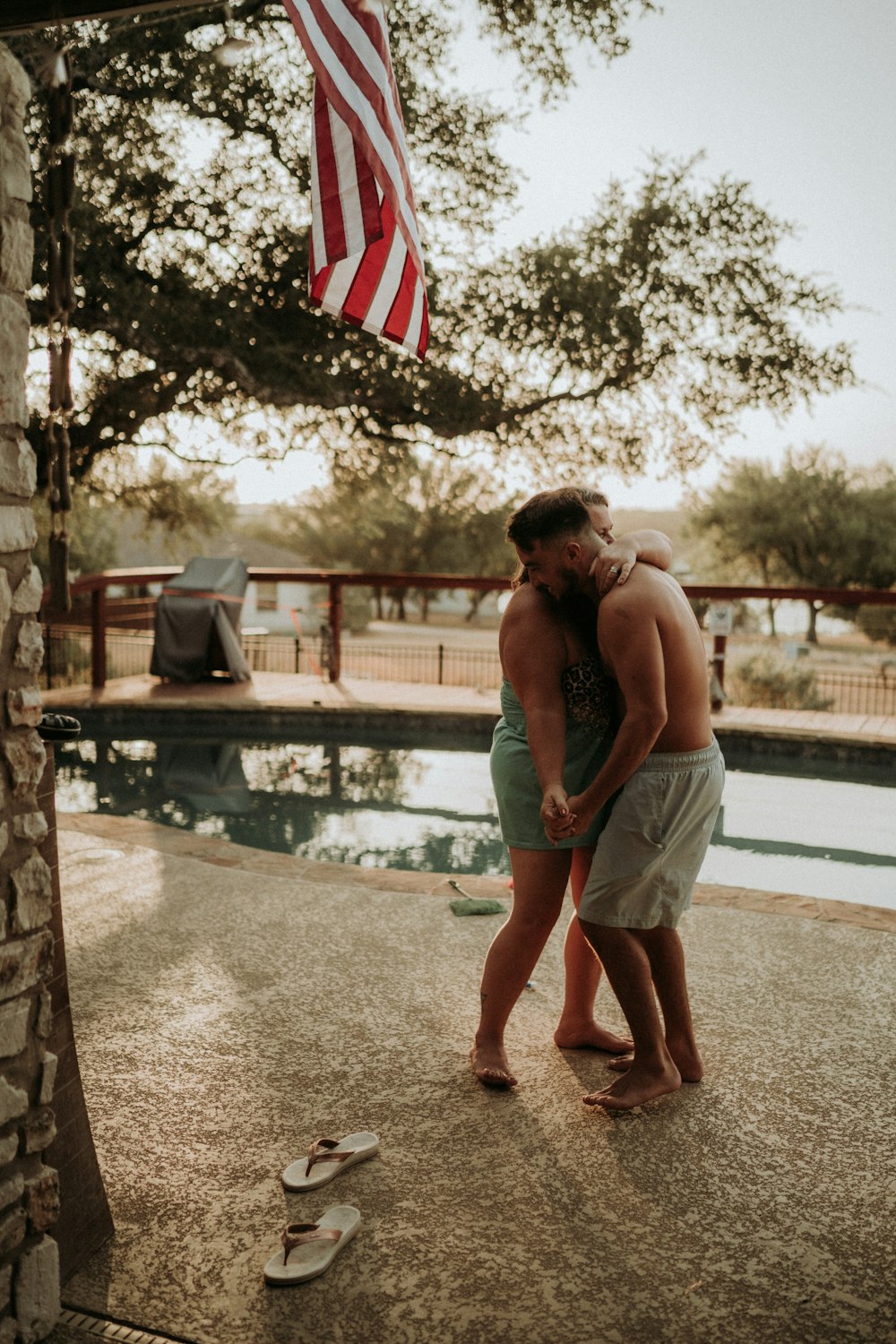 a couple of people standing next to a pool