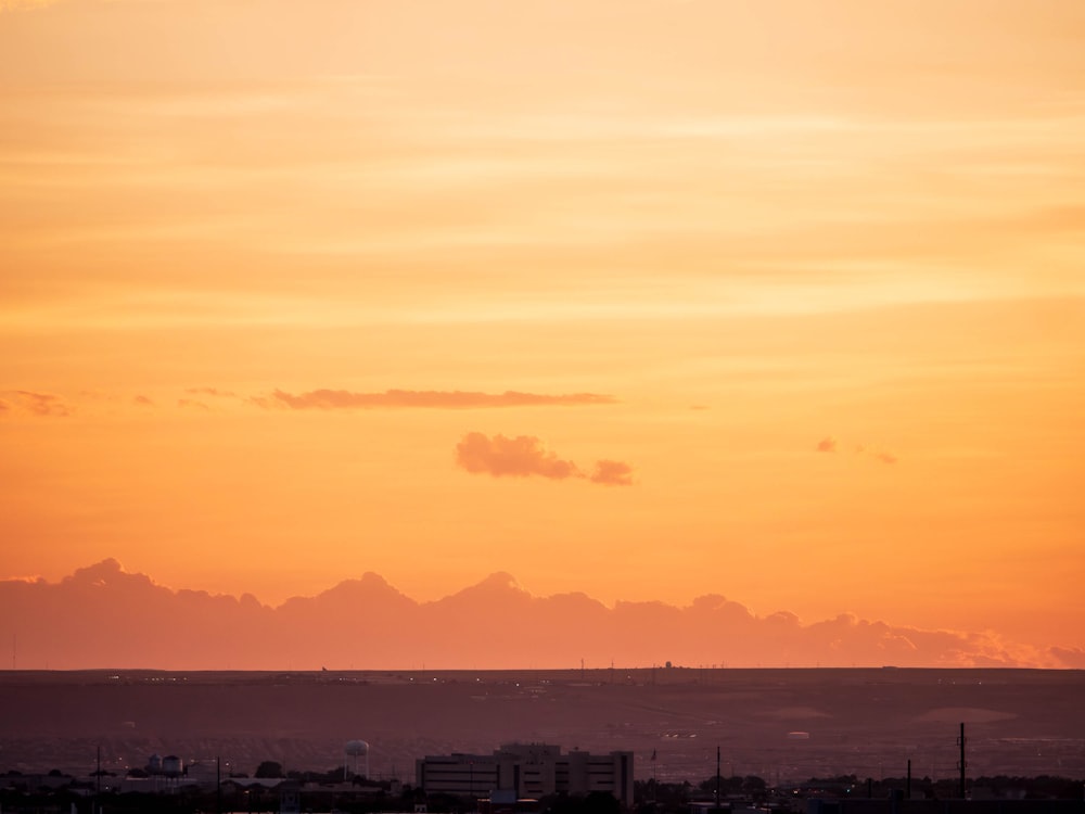 a plane flying in the sky at sunset